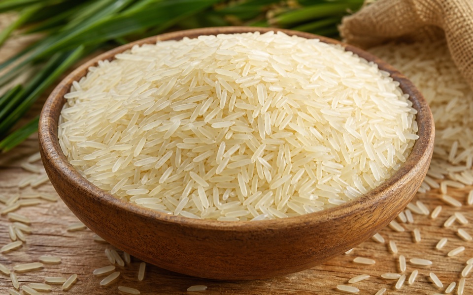 White rice grains in a wooden bowl